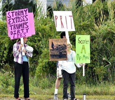 Stormy supporters hold signs across from a “Gentlemen’s Club” in Salisbury