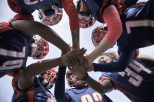 female professional football players in huddle | Quincy News About Quincy Massachusetts